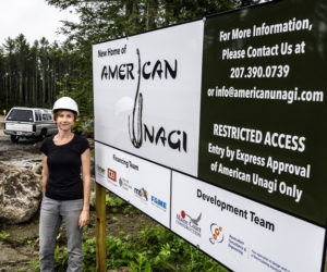 Sara Rademaker, founder and president of American Unagi, stands in front of a sign at the construction site for her 27,000 square foot facility in Waldoboro on July 19. Rademaker said this moment represents the dream she has had for seven years of building an aquaculture business in Maine. (Bisi Cameron Yee photo)