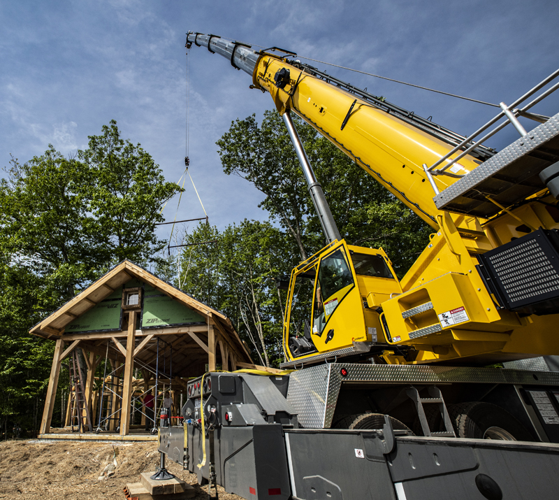 A crane settles the roof in place on an innovative home in Waldoboro on June 5. The house is being designed and built by C.J. Turner, of the Damariscotta-based Alpine Contracting Services LLC. (Bisi Cameron Yee photo)