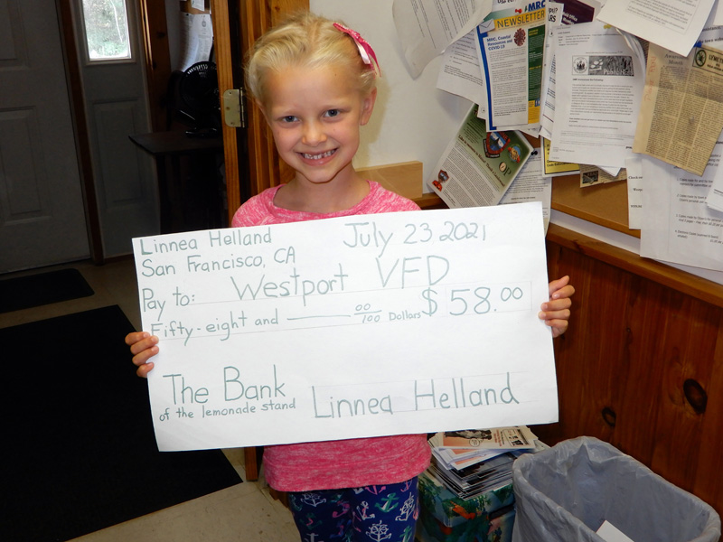 Linnea Helland, 6, holds a check she made to present to the Westport Island Volunteer Fire Department. The check is a portion of the proceeds she gained from her lemonade stand during the town-wide yard sale on July 18. (Photo courtesy Gaye Wagner)