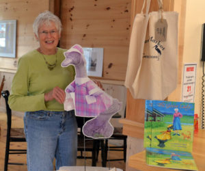 Jefferson summer resident Sally Kinkade holds up a picture of the concrete goose that belong to her mother Marjorie Bean Scott. Scott and the goose are the subject of a new children's book "The Goose Lady," by Barbara A. Walsh. (Paula Roberts photo)