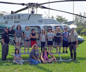 Maine Forest Ranger Pilot Chris Blackie (far left) and Ranger Daniel Welch (far right) stand with campers from the Central Lincoln County YMCA's First Responders Camp. The day marked the end of the first year of the week-long camp at the YMCA. (Nate Poole photo)