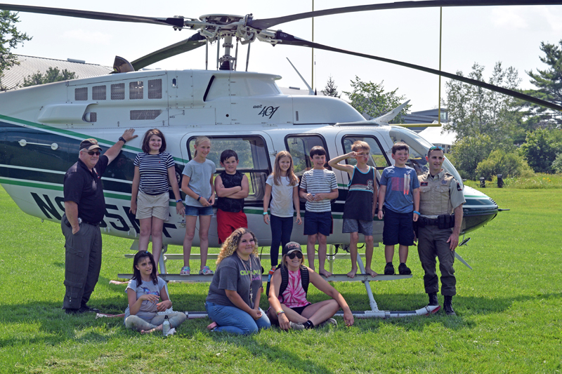 Maine Forest Ranger Pilot Chris Blackie (far left) and Ranger Daniel Welch (far right) stand with campers from the Central Lincoln County YMCA's First Responders Camp. The day marked the end of the first year of the week-long camp at the YMCA. (Nate Poole photo)