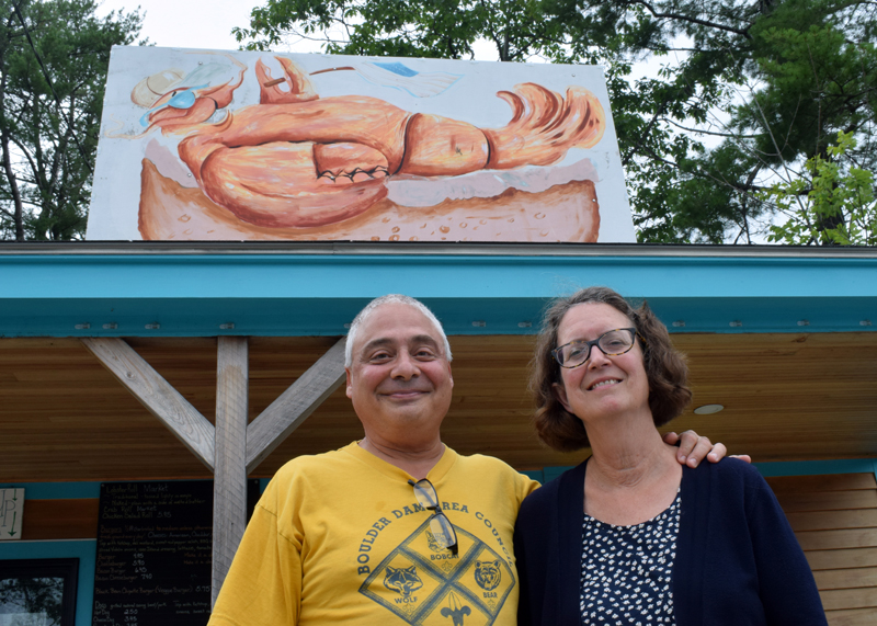 Billy and Barb Ganem, owners of Larson's Lunch Box, stand outside the roadside eatery and the sign handpainted by Newcastle artist Glenn Chadbourne, on Tuesday, Aug. 10. The couple announced in a Facebook post on Sunday, Aug. 8 that they closed the business and will be selling it. (Evan Houk photo)