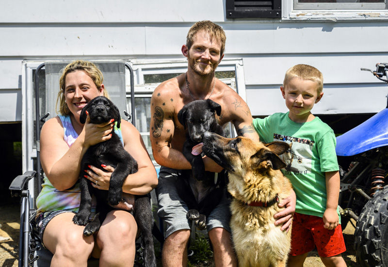 The Genthner family celebrates the return of puppies Haven and Diesel, and the puppies' mother Izzy on Friday, July 30. The puppies went missing on Tuesday night, but returned home safely the next day. (Bisi Cameron Yee photo)