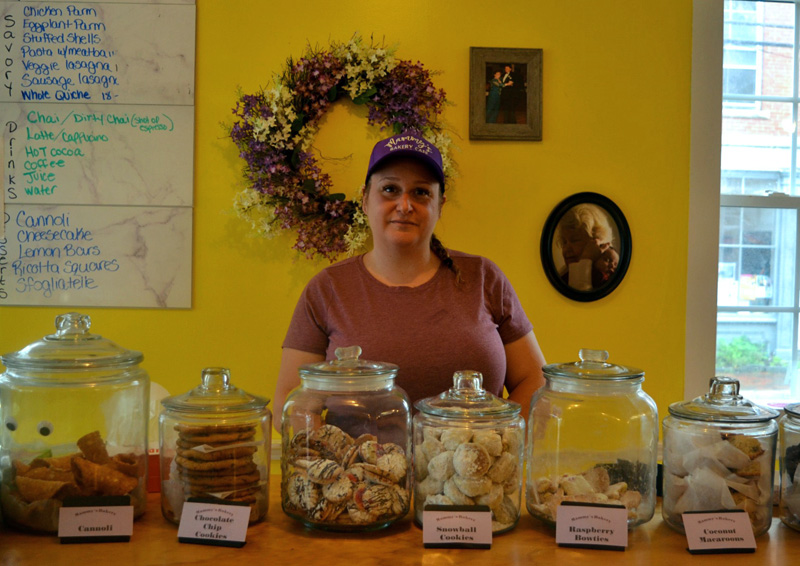 Jessica Deshiro, owner of Mammy's Bakery in Wiscasset Village, stands behind a case of homemade Italian pastries. (Photo by Nettie Hoagland)