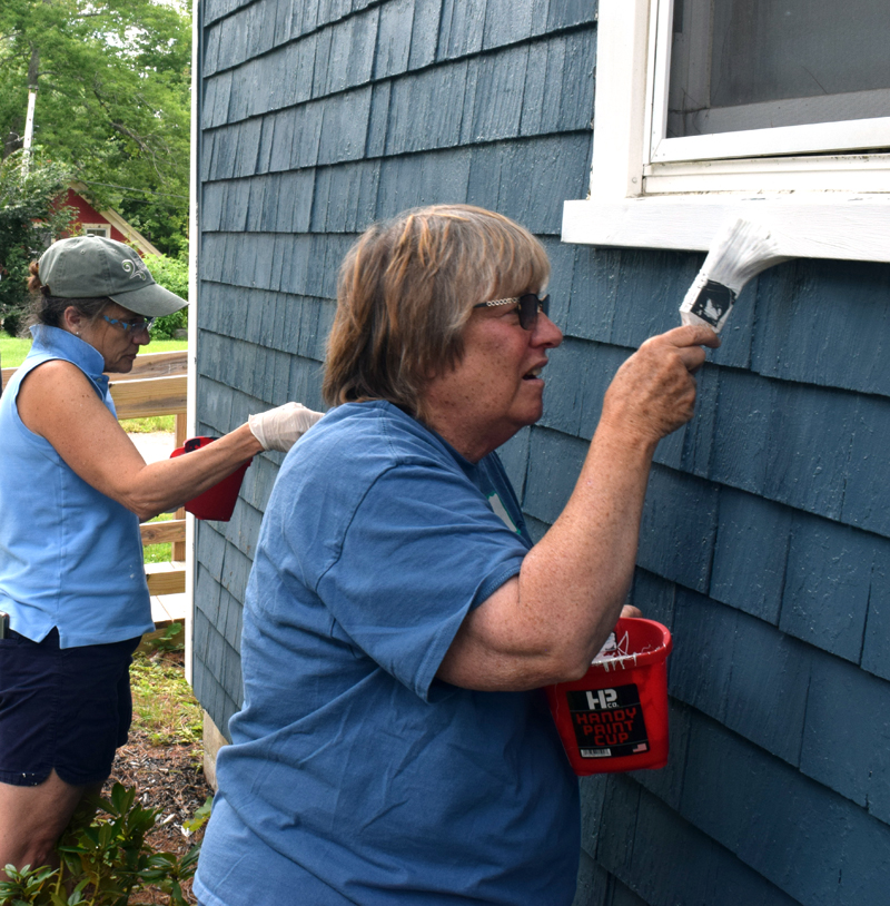 Stepping Stone Housing, Inc. President Marilee Harris and board member Carolyn Neighoff paint a house at Blue Haven, a neighborhood in Damariscotta where the nonprofit owns six homes that are provided as affordable housing options, during Community Cares Day on Saturday, Sept. 11. (Evan Houk photo)