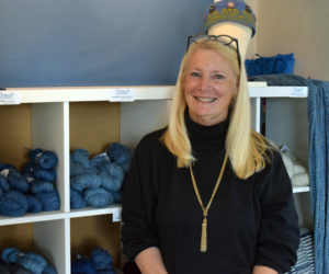 Linda Perry, owner of Sheepscot Harbor Yarns at 74 Main Street in Damariscotta, stands in front of her most popular product, four different shades of hand-dyed indigo yarn that Perry dyes herself at her home on David Island in Edgecomb. (Evan Houk photo)