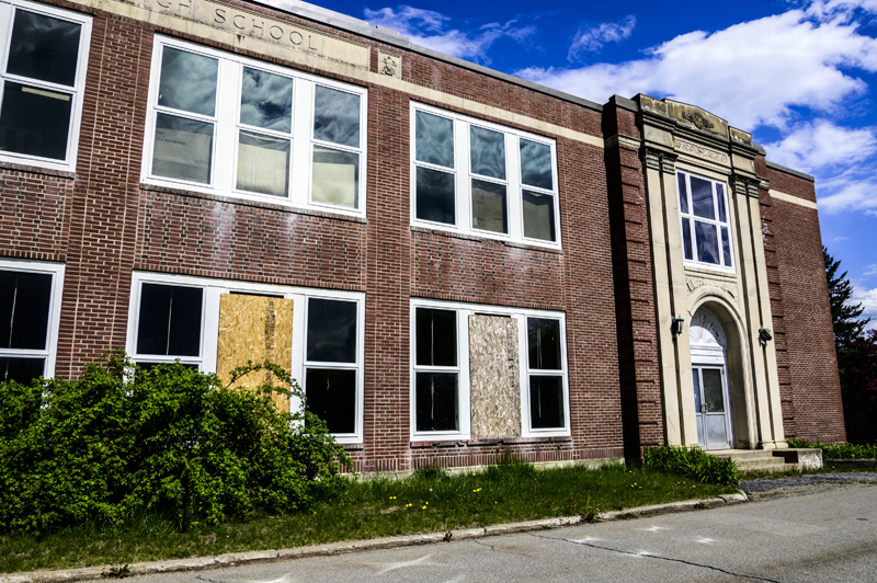 Boards cover broken windows on the front of the A.D. Gray building in Waldoboro on May 14. The brick facade that covers the building has been deemed unstable and the building may need to be demolished. (Bisi Cameron Yee photo, LCN file)