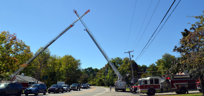 Two of Wiscasset's aerial ladder trucks form a cross over U.S. Route 1 in Wiscasset on Sunday, Sept. 19, during the celebration of life to honor the late Peter Rines. The crossed ladders is a symbol of a bridge to a deceased fireman's next life.  (Charlotte Boynton photo)