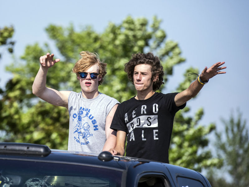 Two Medomak Valley High School seniors wave from a sunroof during a motorcade to celebrate the class of 2021 in Waldoboro on June 6. (Bisi Cameron Yee photo)