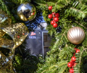 A trailer created as temporary housing for military veterans is seen through a wreath in Waldoboro on Nov. 20. Proceeds from the sale of the wreaths will go toward helping homeless veterans. (Bisi Cameron Yee photo)
