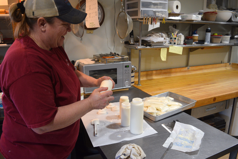 Jennifer Leeman fills bags with frosting for the Cupboard Cafe's holiday cinnamon bun orders on Dec. 12. (Nate Poole photo)