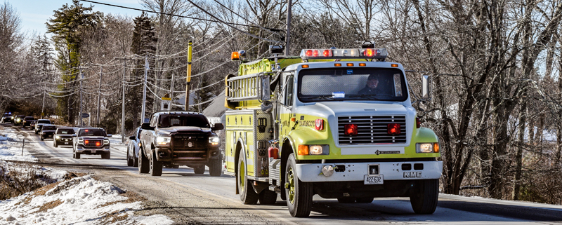 The distinctive yellow Taniscot Engine 5 joins a procession of emergency vehicles traveling from Wiscasset past the Newcastle Fire Department and through downtown Damariscotta to honor 911 supervisor and former Newcastle Fire Deputy Chief Mark Creamer on Dec. 23. Creamer, who worked with Lincoln County emergency services for 27 years, passed away Dec. 22. (Nate Poole photo)