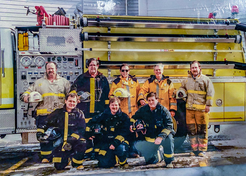 An archive photo of the Newcastle Fire Department featuring Mark Creamer. Creamer retired from the department in 2003. Front row, from left: Bruce Jackson, Brian Foote, and Mark Doe. Back row, from left: Chief Clayton Huntley, Jim Brinkler, Paul Redonnett, James Kelly, Deputy Chief Mark Creamer. (Photo courtesy Newcastle Fire Department)