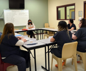 Two Bridges Regional Jail Book Club continue discussing the "American Dirt" at its meeting Dec. 2, with facilitator Anne Schmitt. (Charlotte Boynton photo)