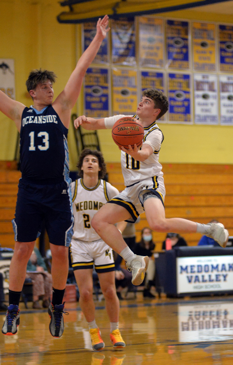 Patrick McKenney drives inside for Medomak Valley, as Oceanside's Bohdi Ames goes for the block. (Paula Roberts photo)