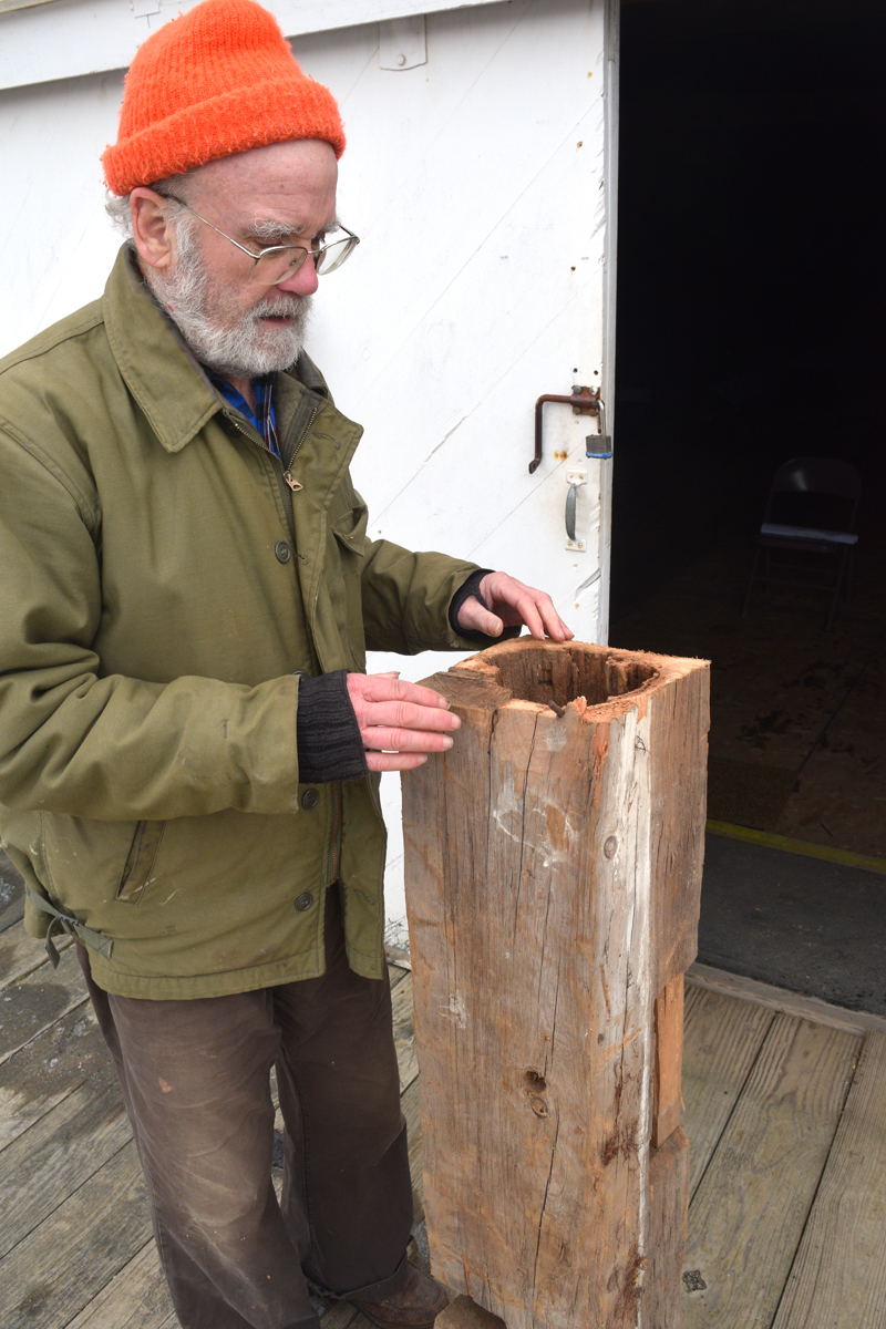 Historical Society Board Member Phil Averill shows off a piece support beam from the Mill at Pemaquid falls to show how it is rotting on the inside on Jan. 13. (Nate Poole photo)