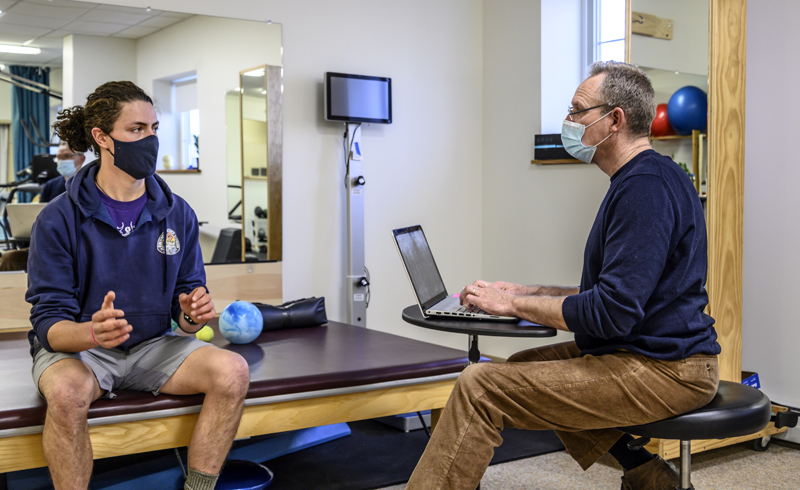 Physical therapist Glenn Flaming (right) takes a history from Logan Huntington at Flaming Physical Therapy in Damariscotta on Dec. 23. Huntington said he is seeking treatment for back pain from a fall while walking on ice. (Bisi Cameron Yee photo)