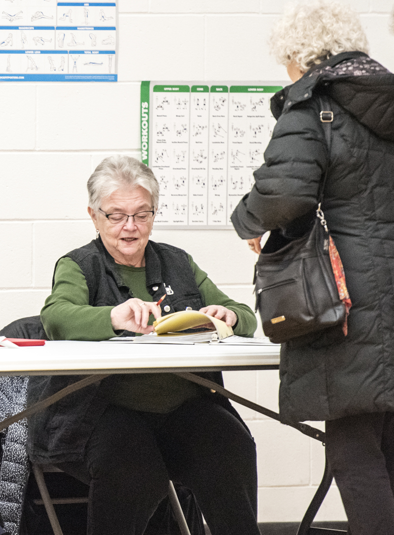 Brenda Williams, left, checks in a voter at a special town meeting in Jefferson on Jan. 14. The meeting was called by the town's board of selectmen to vote on whether to accept a substantial increase in the cost of emergency medical services provided to Jefferson by the town of Waldoboro. (Bisi Cameron Yee photo)