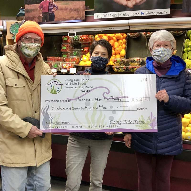 Barbara and Jim O’Halloran from the Jefferson Area Community Food Pantry accept a donation from Rising Tide Co-op team member Carol Manley (center). (Courtesy photo)