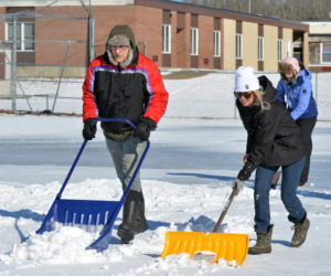 Jeff Sullivan, Nora Parkington, and Angela Sullivan (back) shovel snow off the Whitefield Elementary School baseball field. (Paula Roberts photo)