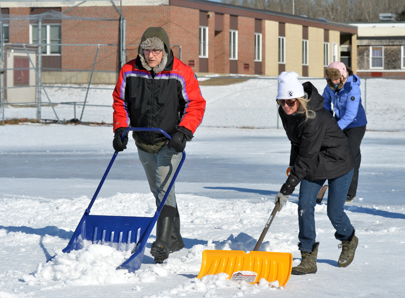 Jeff Sullivan, Nora Parkington, and Angela Sullivan (back) shovel snow off the Whitefield Elementary School baseball field. (Paula Roberts photo)
