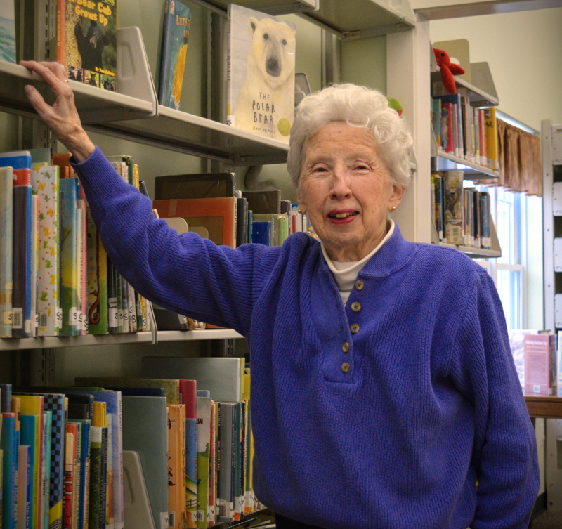 Jean Lawrence, a former Medomak Valley High School teacher and president of the Waldoborough Historical Society, peruses the books she used to read to young visitors in the children's room of the Waldoboro Public Library on Feb. 7. (Nate Poole photo)