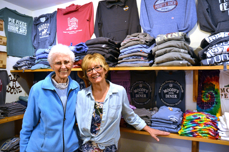 Moody's Gifts owners Nancy Genthner and Mary Olson stand in front of a display of Moody's Diner T-shirts at their Waldoboro shop in 2019. Olson sold the shop in January. (LCN file photo)