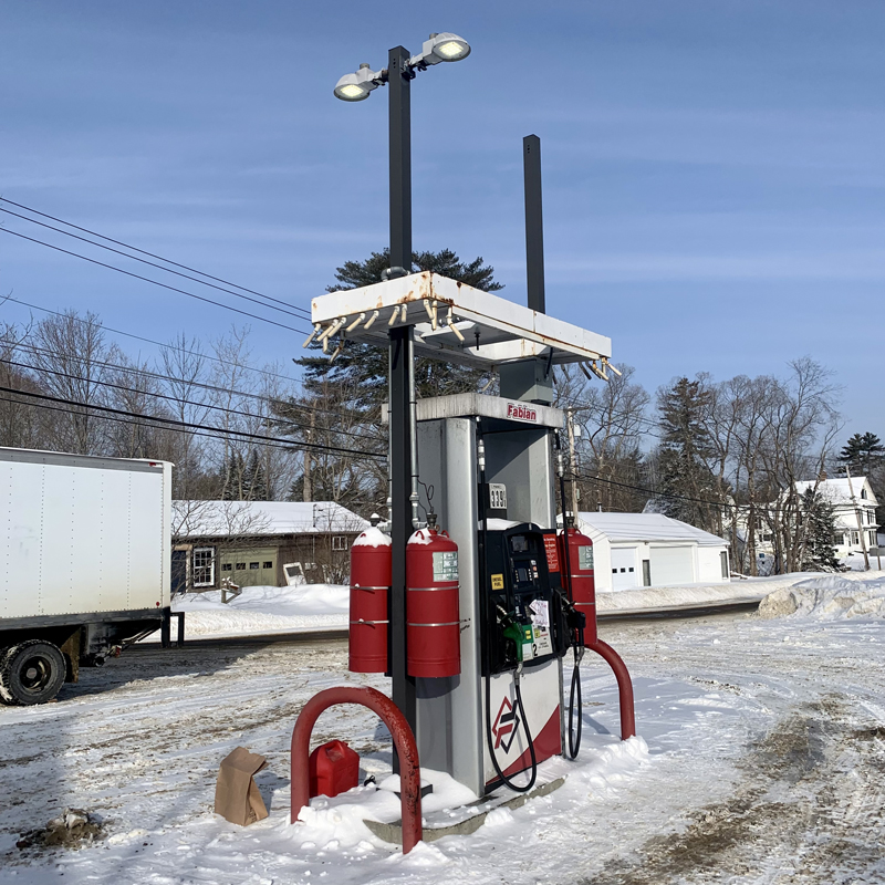 A customer pays for gas inside, leaving their can and bags on the snow beside the pump. (Anna M. Drzewiecki photo)