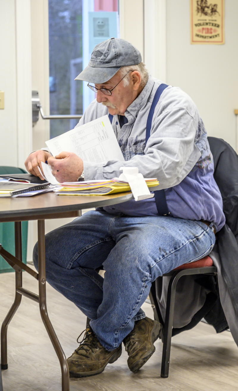 Selectman Richard Powell Jr. reviews documents prior to the selectmen's meeting in Nobleboro on March 9. (Bisi Cameron Yee photo)