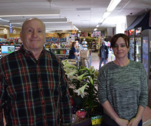 The new owner of Main Street Grocery, Greg Snyder, stands with store manager Julia Small in front of the popular "rose globe" item on April 15. The rose globe is a featured product from the Damariscotta store's new distributor, Associated Grocers of New England, that has been selling fast. (Evan Houk photo)