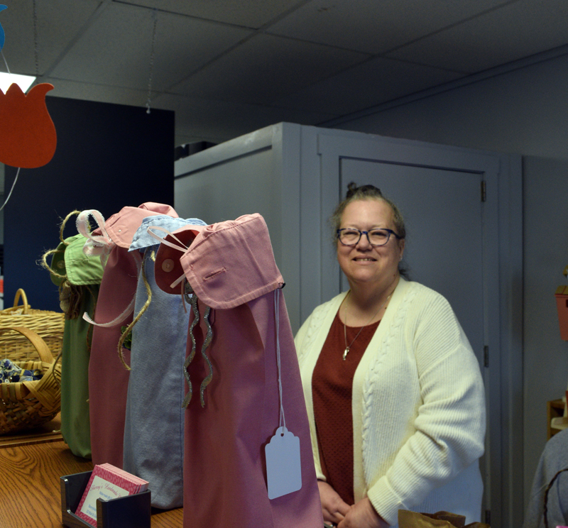 Sherry Resch, owner of Sherry's Handmade in Damariscotta, stands behind some wine bottle bags she made form shirt sleeves on April 11. The consignment shop features handmade arts and crafts from 16 Maine artisans. (Evan Houk photo)