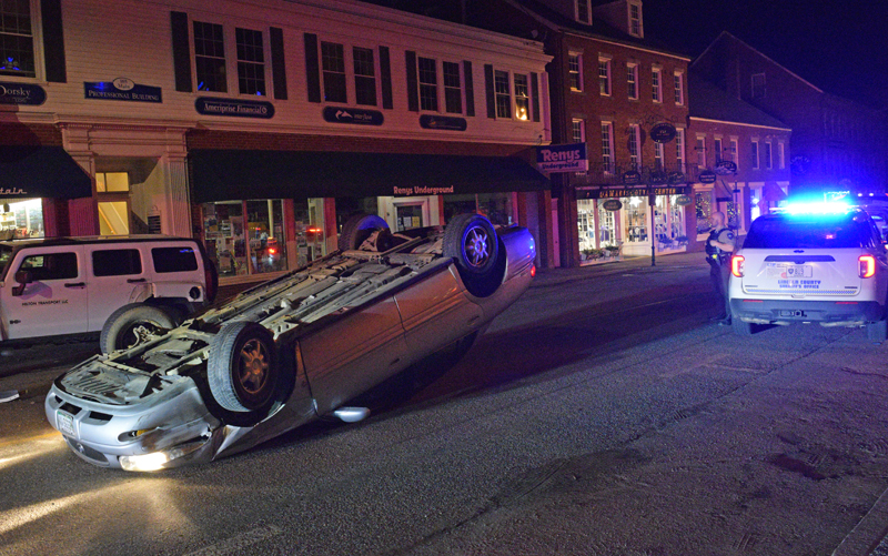 A Lincoln County Sheriff's Office deputy surveys the scene of a rollover in downtown Damariscotta on the early morning of Wednesday, April 13. The car drifted into a parked vehicle on Main Street and flipped over. The driver was not injured. (Evan Houk photo)