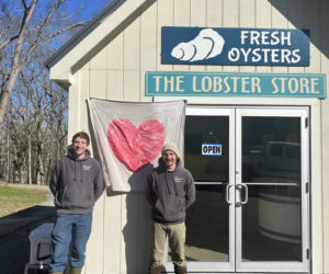 Andy Rogers, left, and Ryan Jolie stand in front of Scully's Sea Products on River Road in Edgecomb. They purchased the business from Barb Scully in January. (Anna M. Drzewiecki photo)