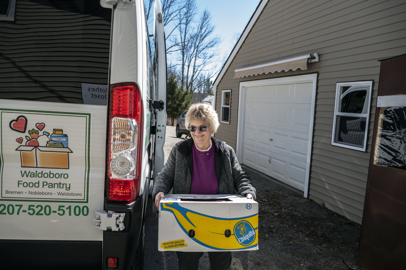 Janet Lee smiles wide as she unloads a box of produce after the maiden voyage of the Waldoboro Food Pantry van in Waldoboro on April 4. Lee is the organization's current operations manager, but advocated for the van when still a volunteer. (Bisi Cameron Yee photo)