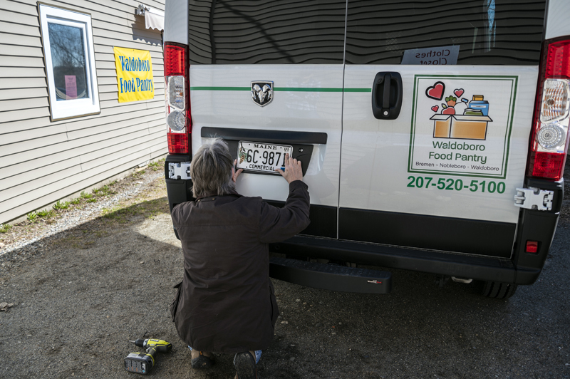 Jan Visser puts permanent plates on the back of the Waldoboro Food Pantry's new Dodge Ram 3500 van in Waldoboro on April 4. The vehicle was paid for with the more than $50,000 raised during the pantry's first annual fundraiser. (Bisi Cameron Yee photo)
