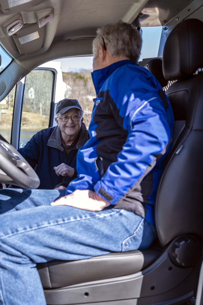 Bill Blodgett talks cars as maintenance coordinator Dale Turner tests out the driver's seat of the Waldoboro Food Pantry's latest acquisition in Waldoboro on April 4. (Bisi Cameron Yee photo)