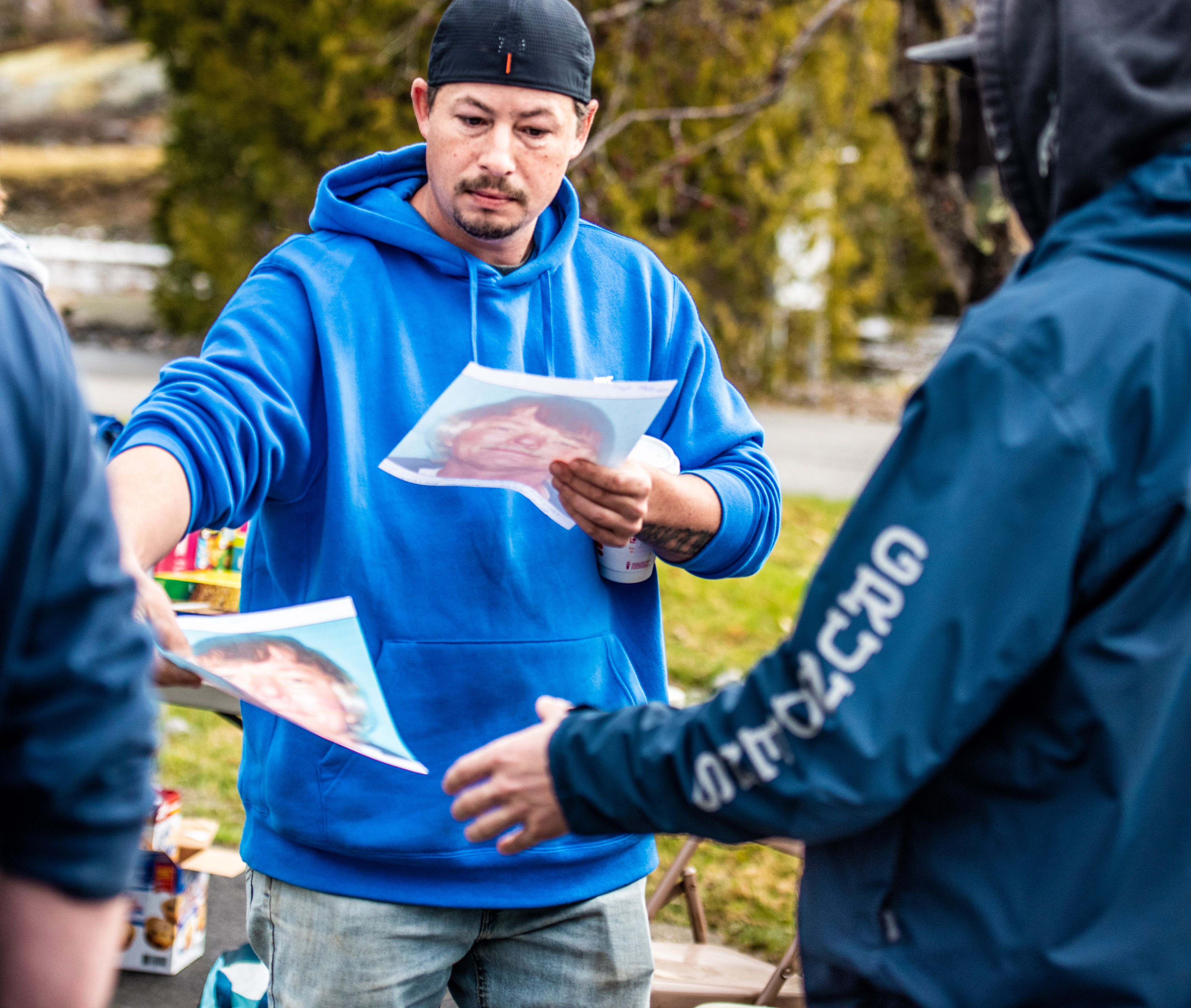 Jimmy Wellman hands out fliers with photos of Doug Barter during a search for the missing man in Waldoboro on April 9. (Bisi Cameron Yee photo)