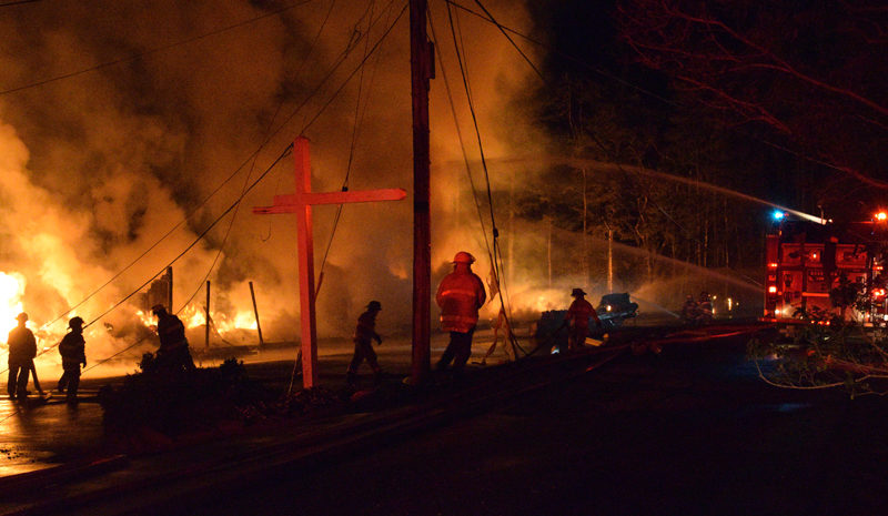 Firefighters work to douse a structure fire with water at the Beach Cove Waterfront Inn, a seasonal hotel in Boothbay Harbor, on Monday, May 23. Crews from at least eight different fire departments in Lincoln County responded mutual aid to the blaze that destroyed the large hotel. (Evan Houk photo)