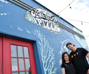 Caroline Zeller and Nick Krunkkala, new operators of Oysterhead Pizza Co. in downtown Damariscotta, stand outside the restaurant and its mural on May 3. The eatery is now offering breakfast sandwiches on Saturday and Sunday as well as lunch sandwiches. (Evan Houk photo)