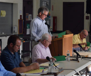 Moderator Jim Cosgrove reads a warrant article during the open portion of Damariscotta's annual town meeting as the Damariscotta Select Board looks on at Great Salt Bay Community School on Wednesday, June 15. All articles were approved with no discussion and all the referendum articles from annual town meeting were approved at the polls the day before. (Evan Houk photo)
