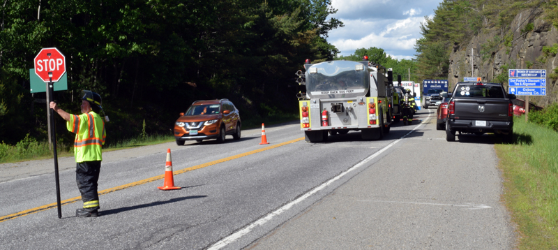 A Newcastle firefighter directs traffic on Route 1 in Newcastle after a red GMC Acadia left the roadway and hit the rock ledge on the side of the road. Route 1 was reduced to one lane of traffic for less than 30 minutes while the scene was cleaned up. (Evan Houk photo)