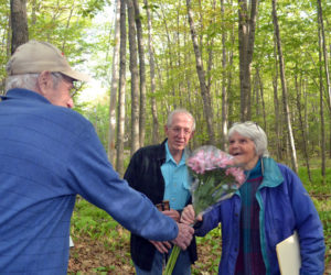 Westport Island First Selectman George Richardson presents flowers to Barbara Thompson at the 50th anniversary of the establishment of Clough Point Preserve, on Monday, May 23. Thompson helped raise funds for the town to purchase the Clough Point property in 1971. (Charlotte Boynton photo)