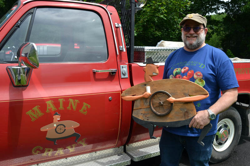 Maine Gravy owner and "saucemaster" Dick Chase holds Dave, the inspiration behind his hot sauce company's logo, in front of The Heatmobile. Chase, of Damariscotta, received permission from William "Bill" Skrips, the artist who created the piece, to modify Dave for the Maine Gravy bottles on Chase's line of hot sauces. (Maia Zewert photo)