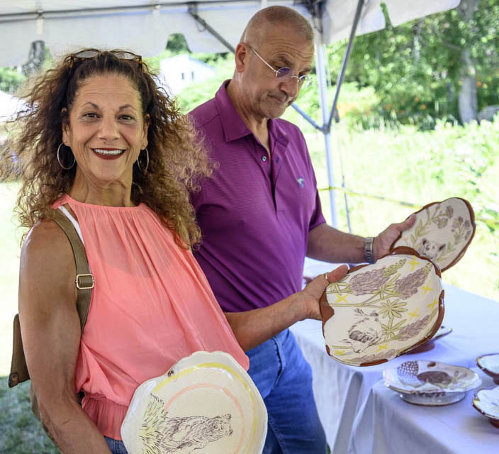 Jan Tessein holds up two plate possibilities while husband Ernie considers yet another option during Salad Days at Watershed Center for the Ceramic Arts in Newcastle on Saturday, July 9. Their daughter, Grace, is the Salad Days artist-in-residence. (Bisi Cameron Yee photo)