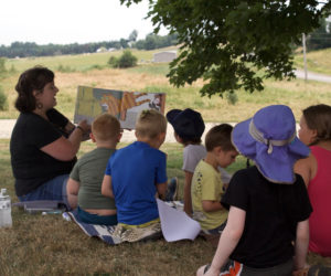 Emma Nelson read to Whitefield Library story time attendees at during a field trip to Sheepscot Valley Farm on July 18. (Iris Pope photo)