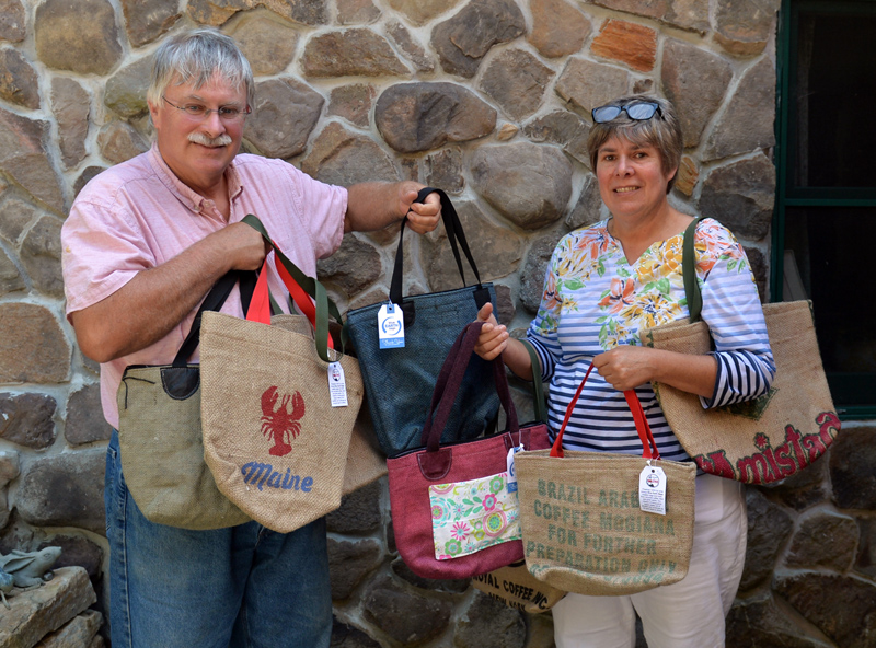 Blue Earth Bags owners Rusty and Kim Fenn hold up a variety of bags they made out of recycled materials. (Paula Roberts photo)