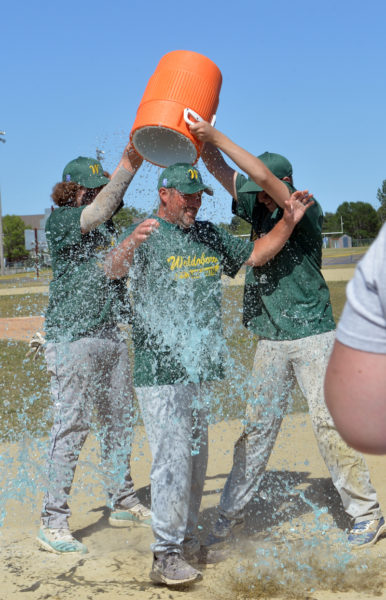 Jacob Hendrickson and Liam Winchenbach empty a water cooler on top of coach Andy Havener after Waldoboros win at the Mid Coast Babe Ruth championship. (Paula Roberts photo)