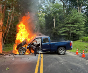 A blue Chevrolet Silverado is engulfed in flames after leaving Biscay Road and striking a tree in Bremen on the evening of Tuesday, Aug. 2. Bystanders and members of the Bremen Fire Department were able to extract the driver, Roy Benner, of Damariscotta, and he was LifeFlighted to Maine Medical Center in Portland. (Photo courtesy Lincoln County Sheriff's Office)