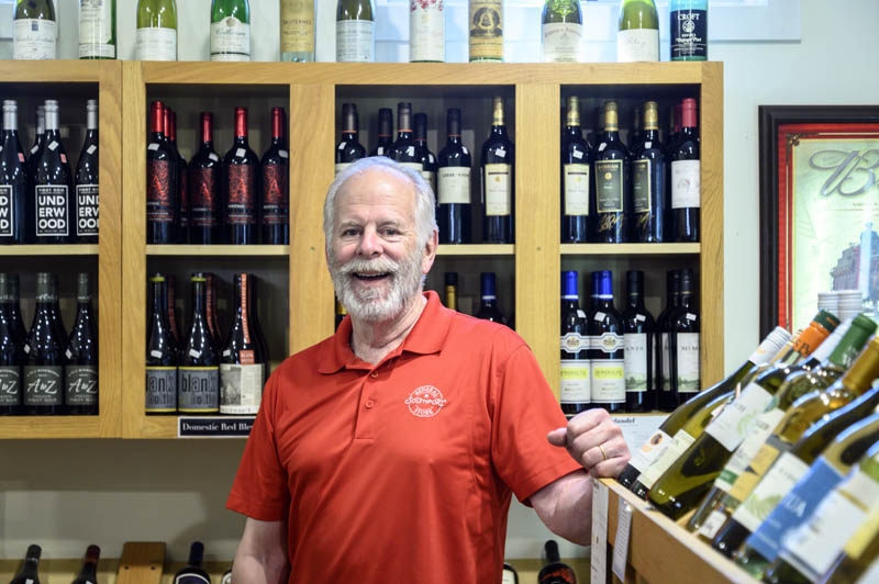 Skip Simonds stands for a photo in the beer and wine department of the Southport General Store on June 30. Symonds curates the department with an eye to great values: a current favorite is a pinot noir called Angelas Ink. From your first sip to your swallow to the aftertaste, it's just gorgeous, he said. (Bisi Cameron Yee photo)
